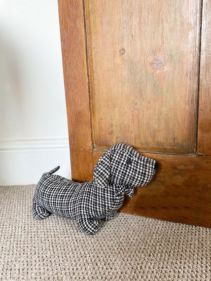 Fabric sausage dog doorstop in a grey and black herringbone pattern