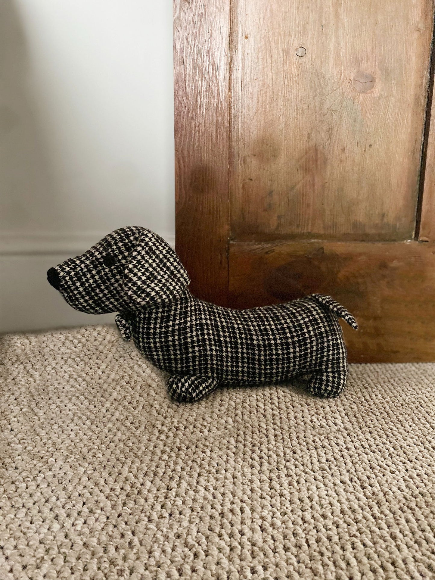 Fabric sausage dog doorstop in a grey and black herringbone pattern