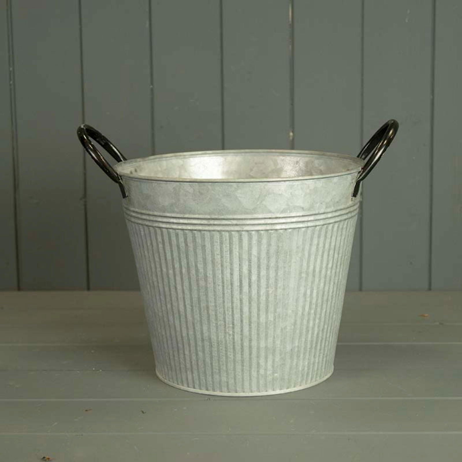 Grey metal planter with ribbed texture and black handles.